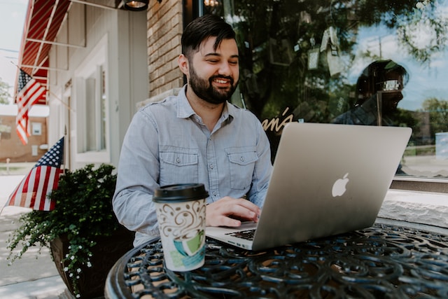 Man playing sports betting and online slots while drinking coffee
