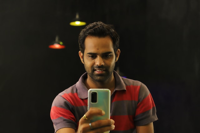 Sports betting enthusiast enjoying online slots on his smartphone